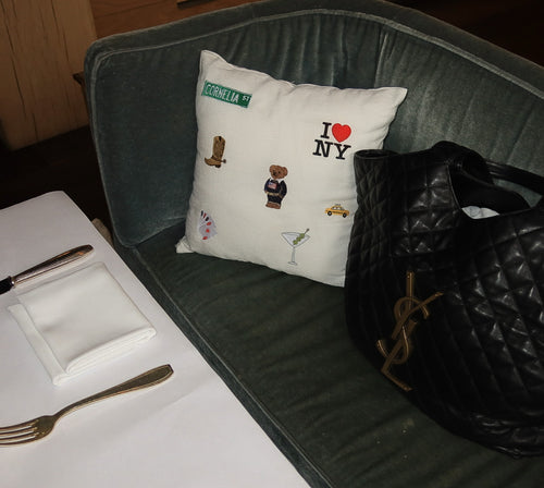 Pillow with embroidered designs on a gray couch