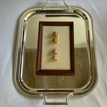 Earrings presented on a gold serving dish