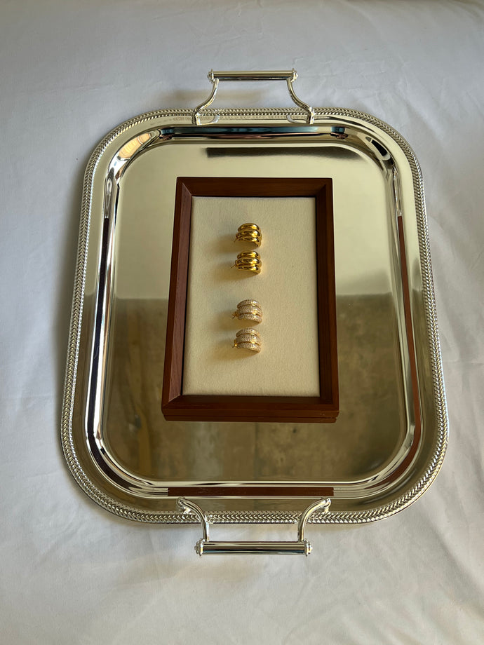 Earrings presented on a gold serving dish