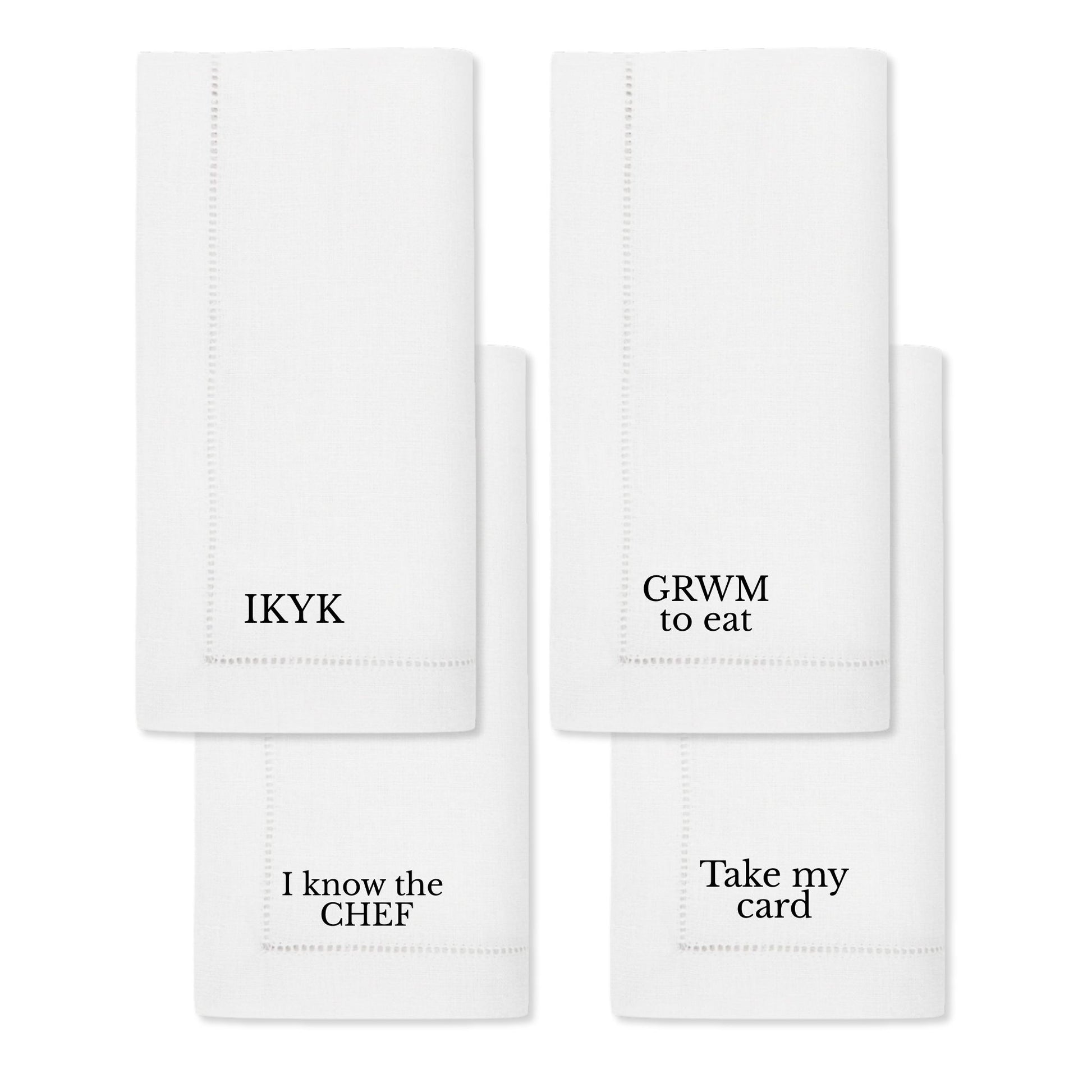 Set of four white cotton napkins with humorous quotes: IKYK, GRWM to eat, I know the CHEF, Take my card.